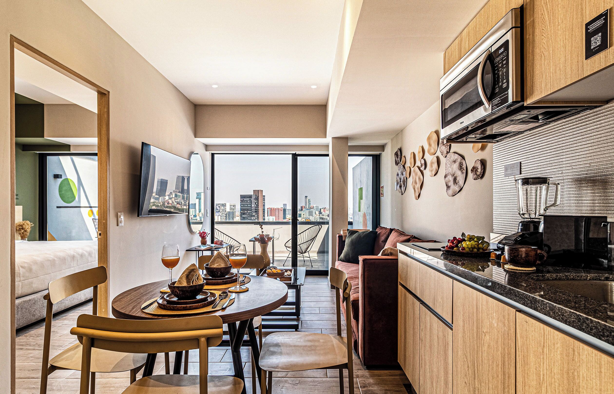 Una cocina funcional con comedor, un sofá y vistas a la ciudad.