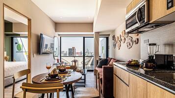Una cocina funcional con comedor, un sofá y vistas a la ciudad.
