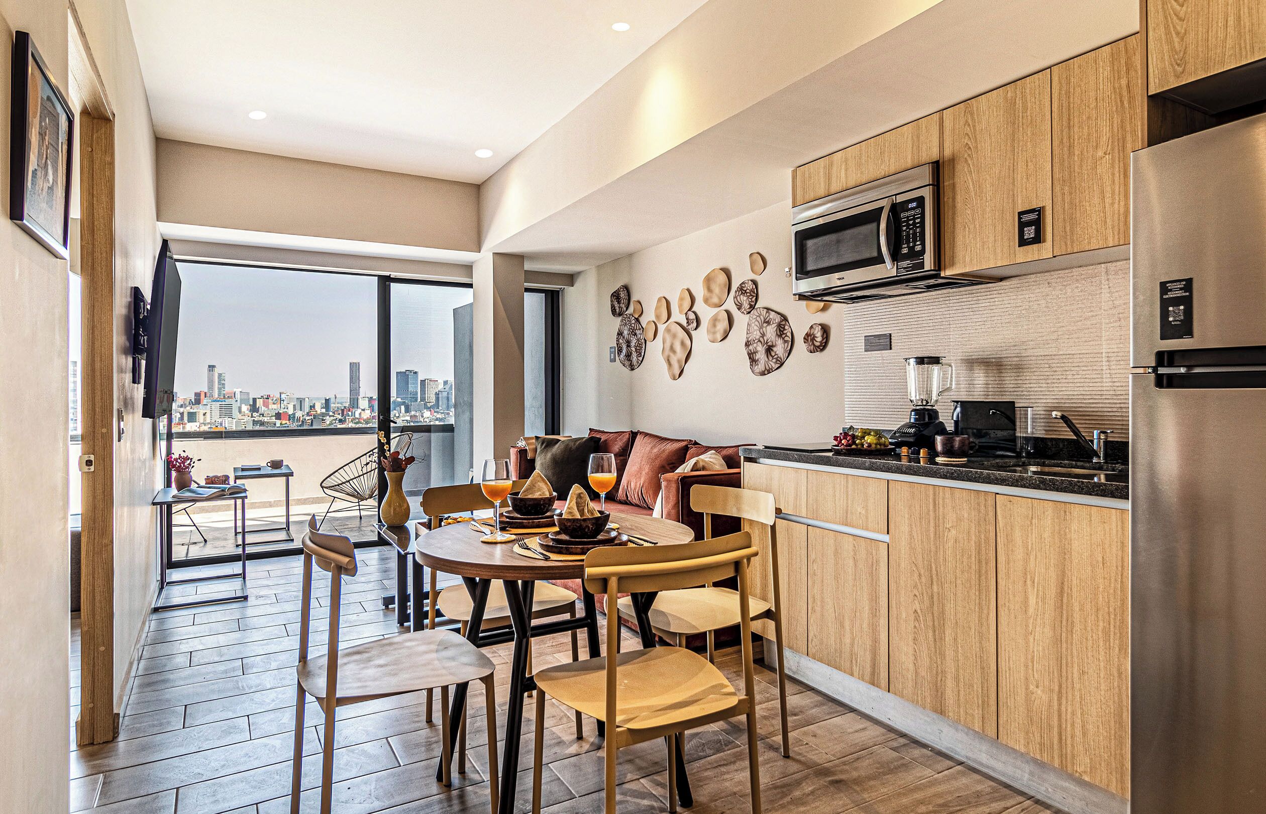 A modern kitchen with wooden cabinets, a built-in microwave, and a stainless steel refrigerator.