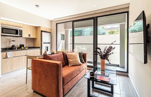 Ein modernes Wohnzimmer mit Sofa, Couchtisch und Blick ins Freie.