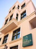 A multi-story building with a sign for Emerald Mansion Hotel.
