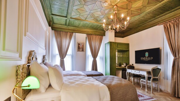 Une chambre d’hôtel avec un lit, un bureau et une télévision.