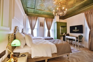 A hotel room with a bed, desk, and television.