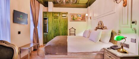 Una habitación de hotel con cama, mesita de noche, lámpara y candelabro.