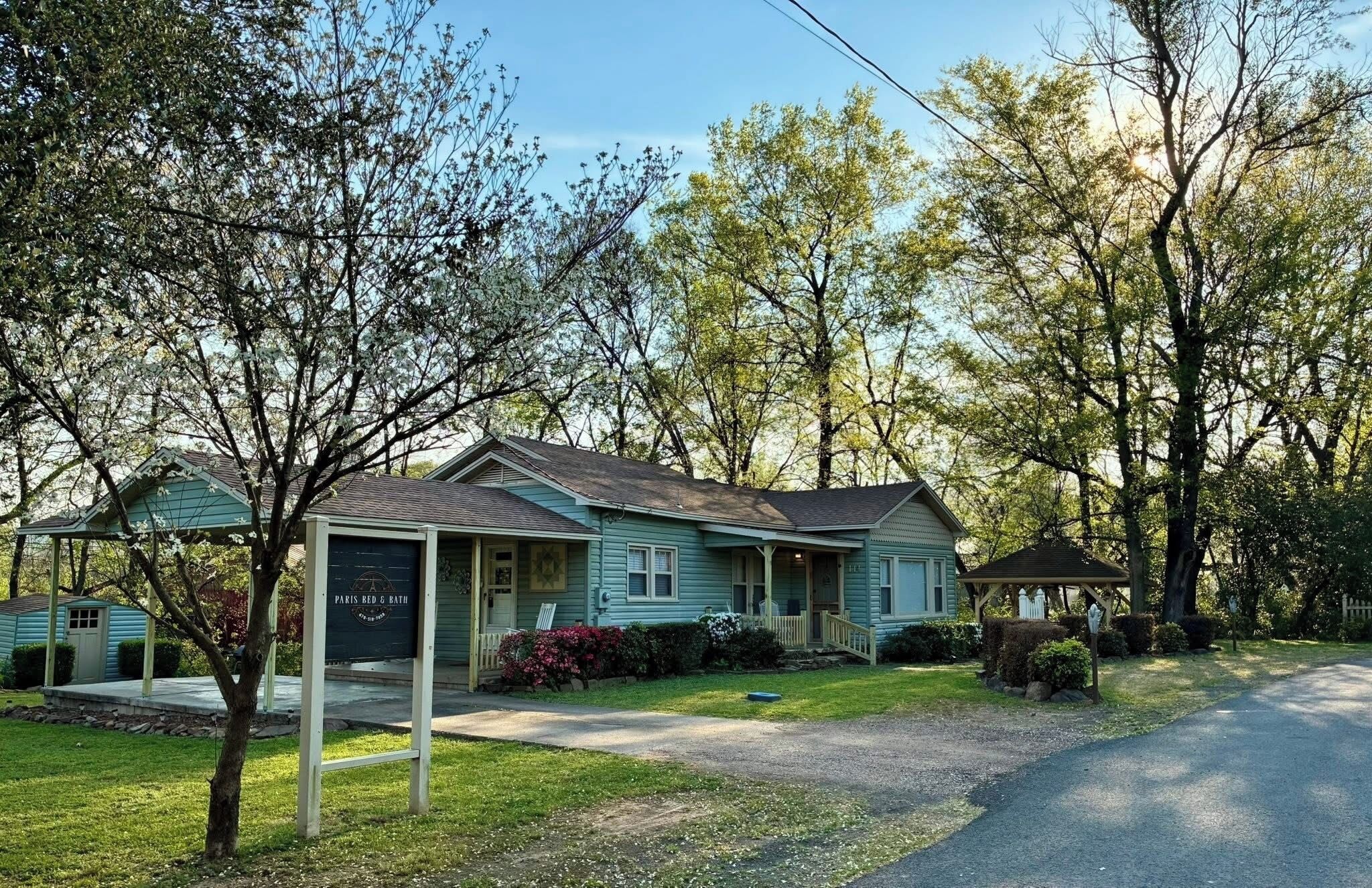 A single-story house with a front porch, a garage, and a small attached shed.