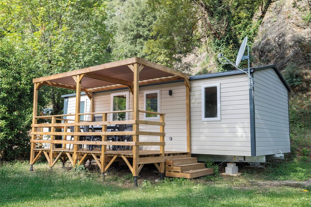 A small cabin with a wooden deck and a satellite dish.