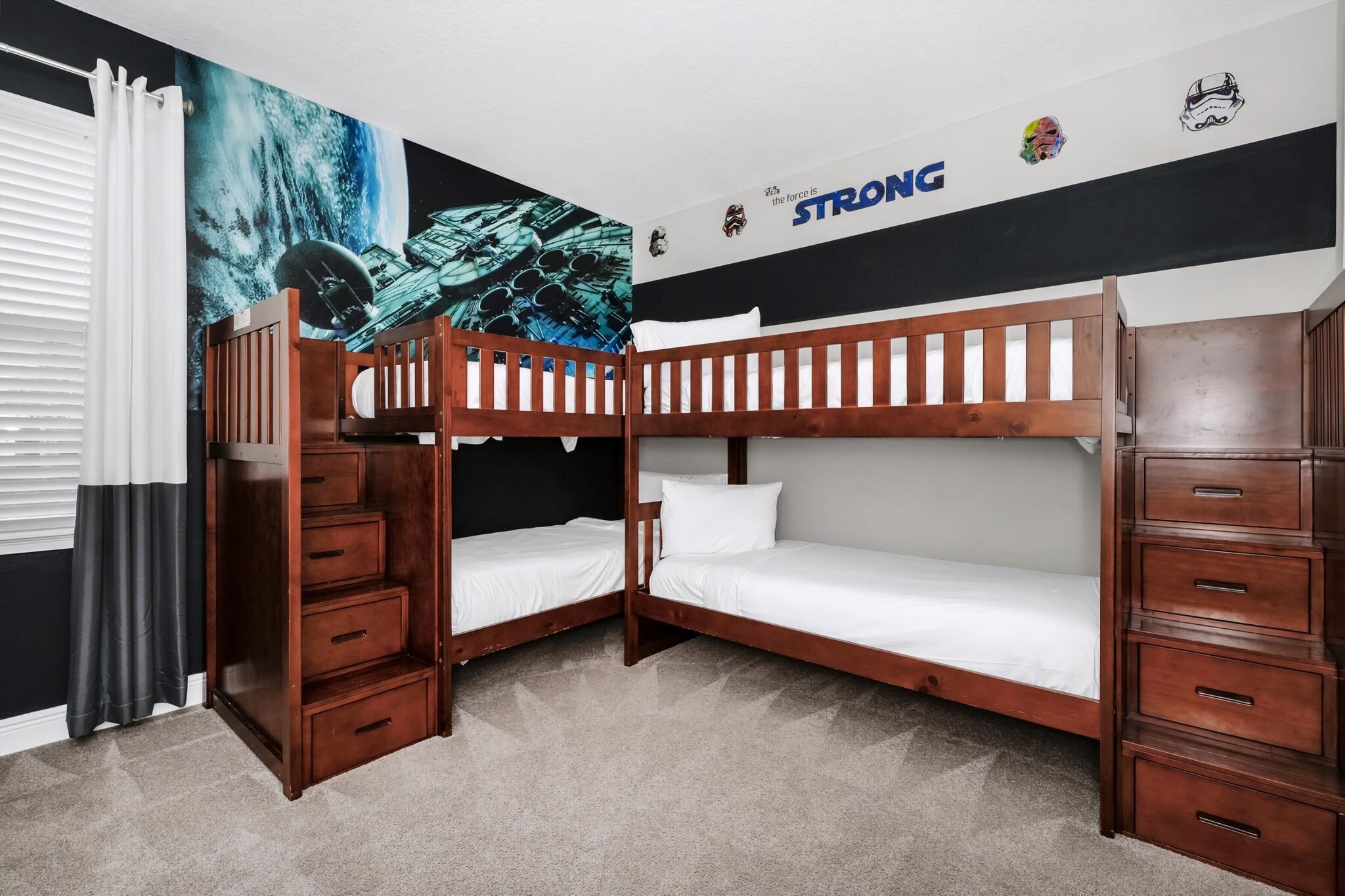 A bunk bed room with a mural, a dresser, and a wall decal saying 'the force is STRONG'.