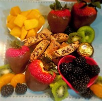 Une assiette de fruits variés et de chocolats.