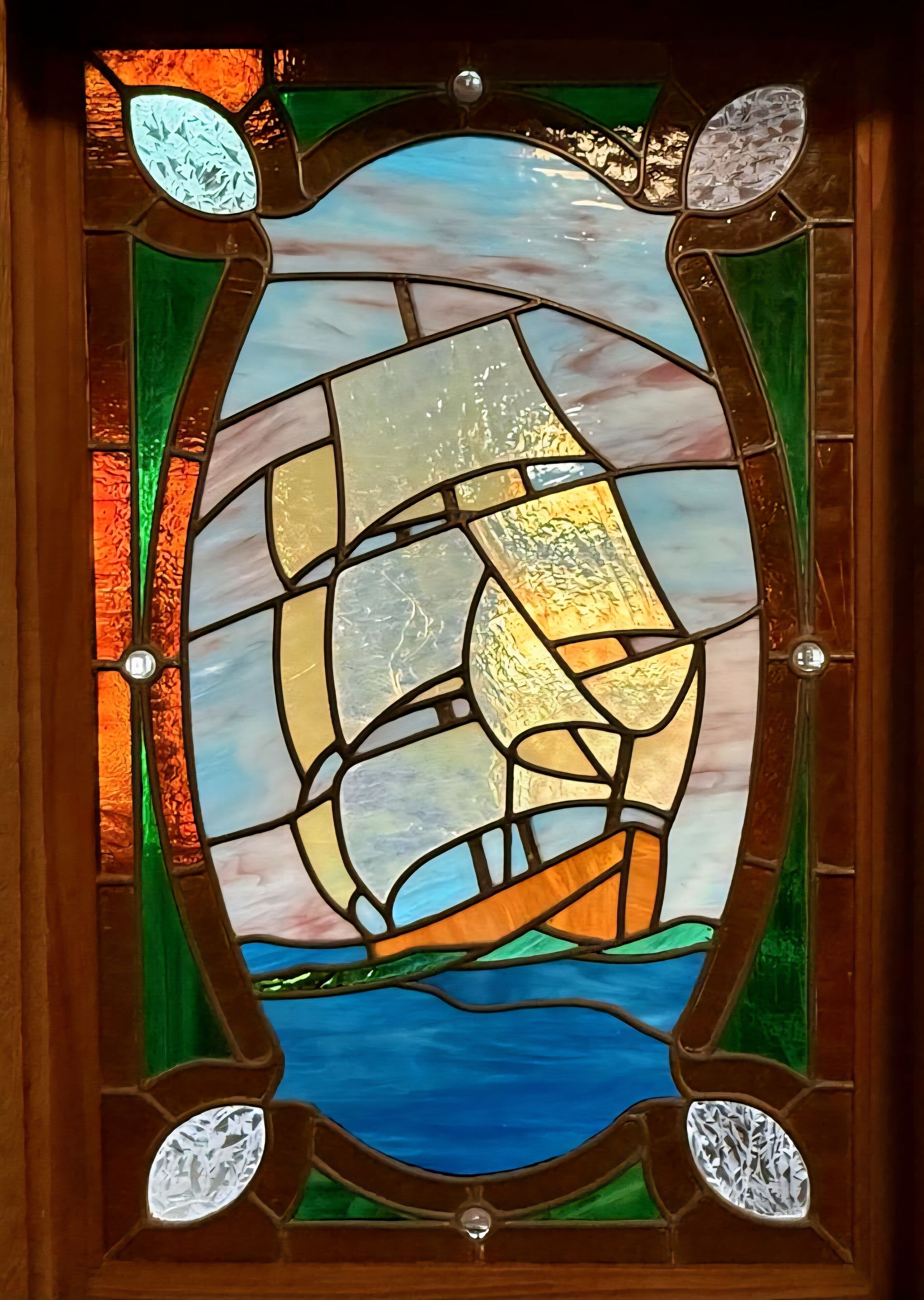 A stained glass window with a ship design.