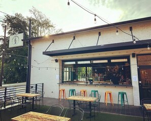 An outdoor seating area with tables and chairs, a bar counter, and a sign for 'The Companion'.