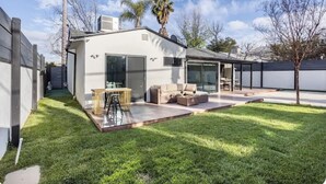 A modern house with a patio, a dining area, and a large sliding glass door.