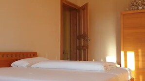 A single bed with white bedding in a room with wooden flooring and a wooden door. - Zimmer in Centrum von Berlin (Berlin)