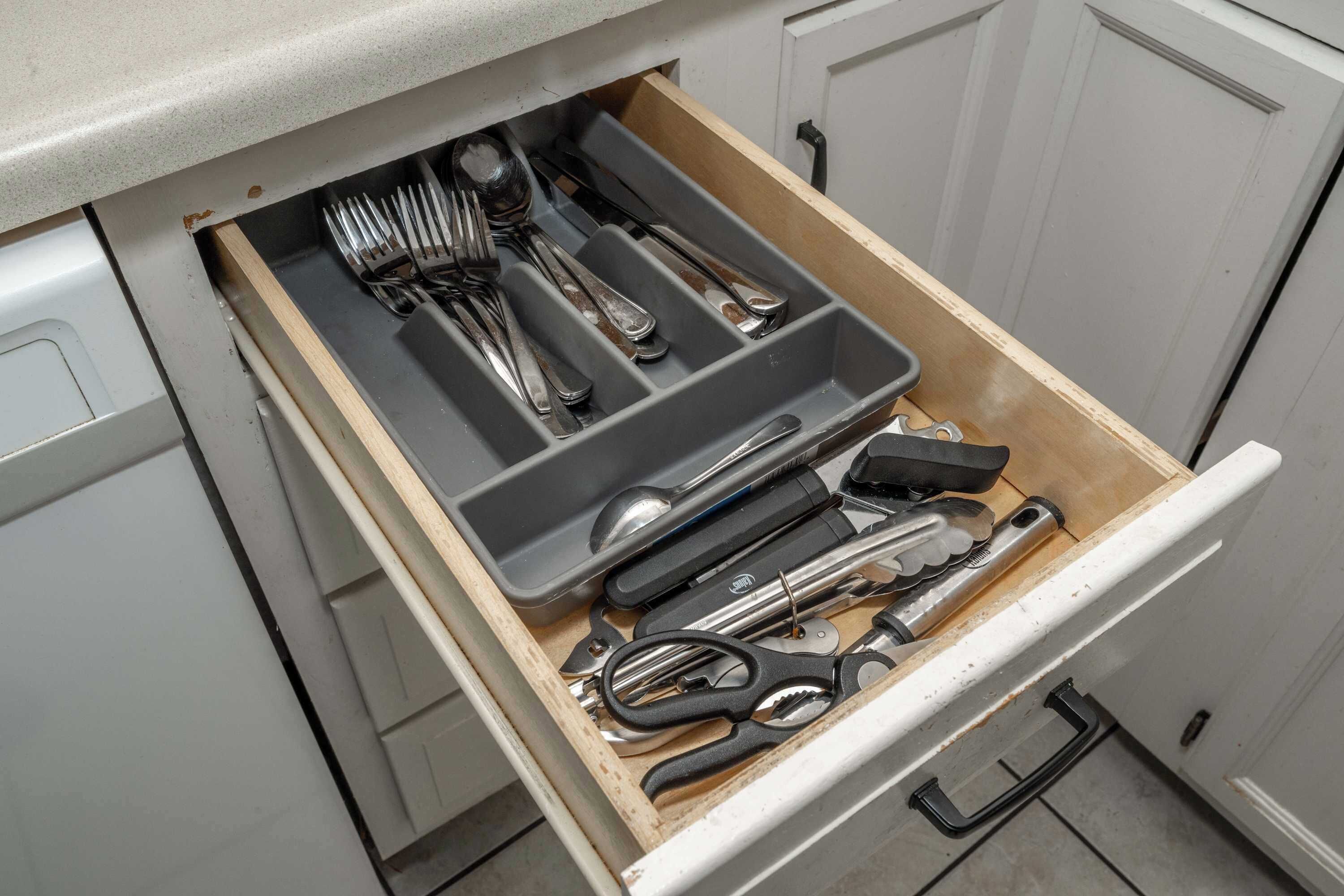Un tiroir de cuisine contenant des ustensiles et des outils.