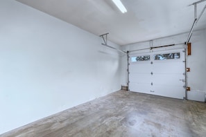 Garagem com piso de concreto e porta branca.