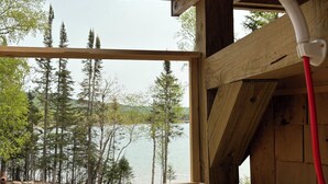 Una baita di legno con vista su un lago e alberi.