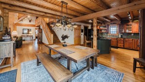 A spacious kitchen with wooden cabinets, a large island, and a hanging light fixture.