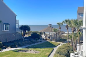 A coastal property with a view of the ocean, a gazebo, and a well-maintained lawn.