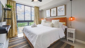 A bedroom with a large bed, a desk, a ceiling fan, and a view of the outdoors. - 5350 Nw Downtown - Doral Building - We Host (Miami)