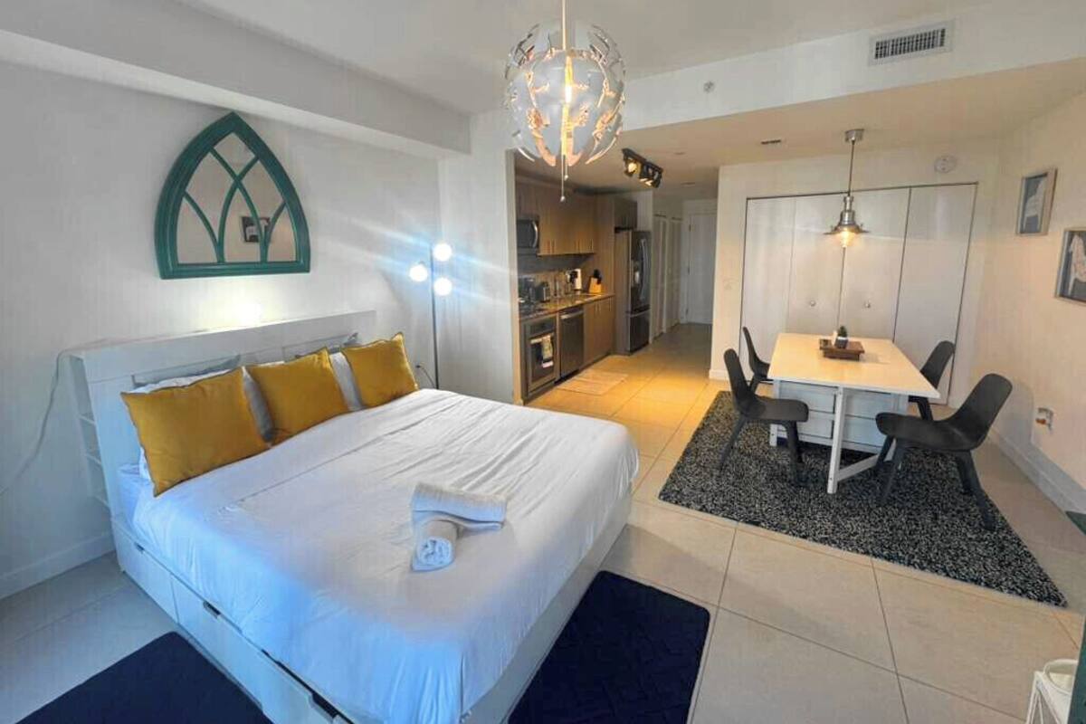 Een moderne hotelkamer met een groot bed, een zithoek en een kitchenette.