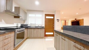 A modern kitchen with wooden cabinets, stainless steel appliances, and a granite countertop.