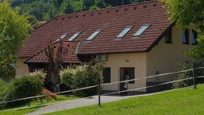 Ein zweistöckiges Gebäude mit einem geneigten Dach, mehreren Oberlichtern und einer beigen Fassade.