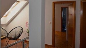 Ein modernes Interieur mit einem Oberlicht, einer Treppe und einem Flur, der zu einer Tür führt.