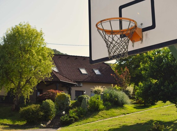 A residential house with a basketball hoop in the foreground.