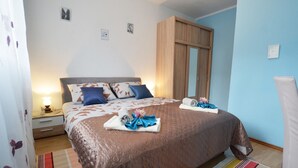 Une chambre à coucher comprenant un lit, des tables de chevet, une armoire et une salle de bain.