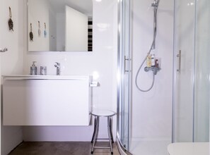 Regadera, secadora de cabello, toallas, papel de baño 