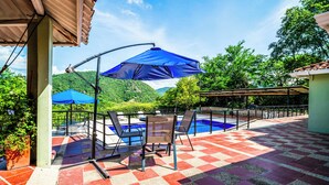 Una terraza con piscina, suelo a cuadros y mobiliario exterior.
