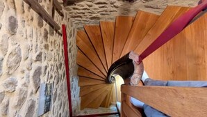 A spiral staircase with a stone wall on one side and wooden steps. - Le Manoir de la Magdeleine (Lanvallay)