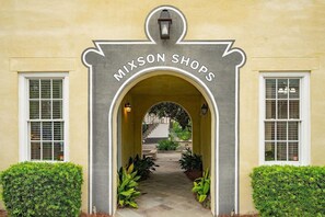 A building entrance with an archway labeled 'MIXSON SHOPS' and a pathway leading to a staircase. - Palmetto Hideaway~Cozy 1br/1ba Townhome (North Charleston)