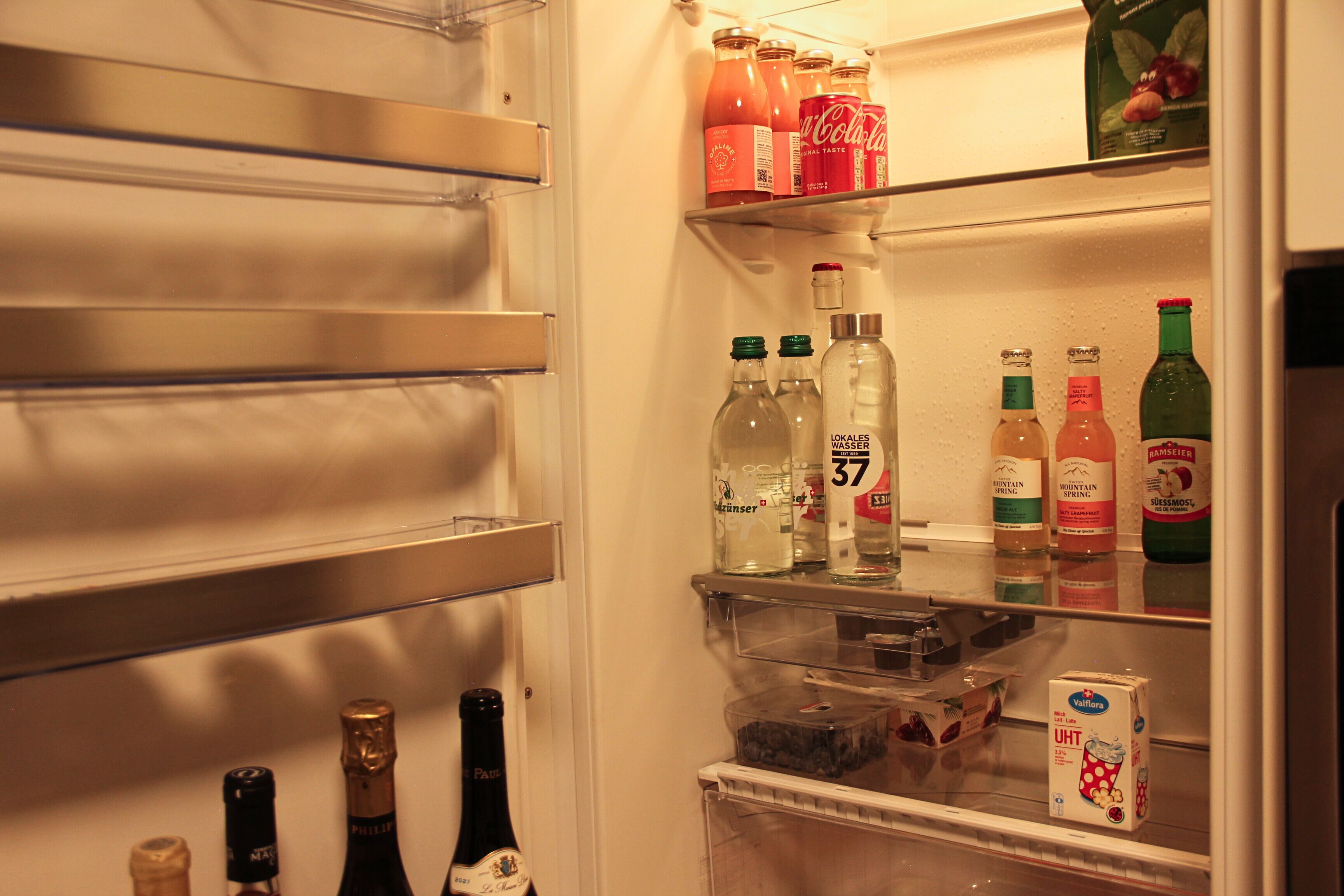 A refrigerator stocked with beverages and food items.