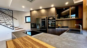 Enjoy cooking in this kitchen with a central island, refrigerator, and stainless steel sink.