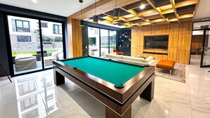 A modern indoor pool table with a green felt surface, surrounded by a wooden frame. - Apartment in Barranco by Artline (Lima)