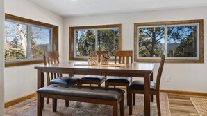 A dining area with a wooden table, four chairs, and a bench. - Mountain View Escape (Estes Park)