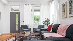 A modern living room with a grey sofa, two armchairs, a wooden coffee table, and a patterned rug. - Spacious ATL Escape, Prime Area Near Everything! 2 King Beds. Walkable & Central (Atlanta)