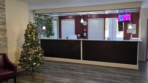 Zona de recepción con un árbol de Navidad, mostrador y asientos.