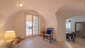 Une pièce spacieuse avec une grande porte en arc donnant accès à un espace cuisine.