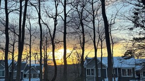 A residential area with houses, trees, and a sunset.