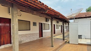 A corridor with tiled flooring, wooden pillars, and a tiled roof. - Hotel Lunna (Porto Nacional)
