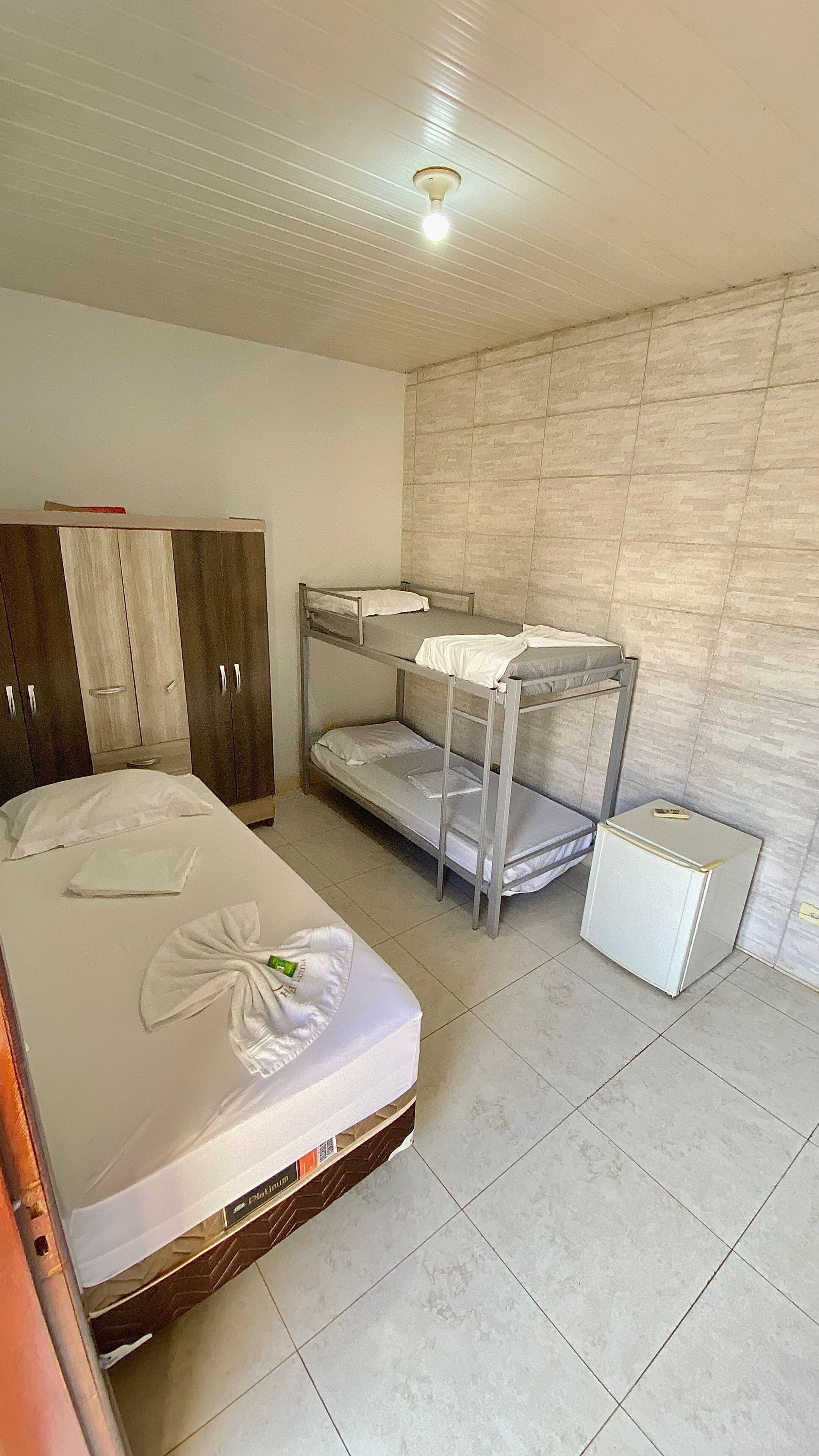 Una habitación con literas, un armario y un pequeño mueble blanco.