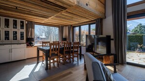 Una cocina moderna con armarios de madera, una mesa de comedor y un televisor.