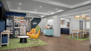 Un hall d’hôtel moderne doté d’un espace salon, d’une kitchenette et d’un mini-bar.
