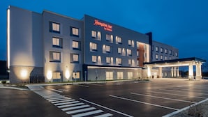 A Hampton Inn by Hilton hotel with a spacious parking lot and a well-lit entrance. - Hampton Inn Cooperstown (Cooperstown)