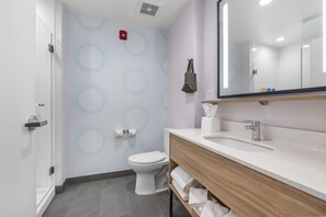 Une salle de bain moderne équipée de toilettes, d’un lavabo et d’un miroir.