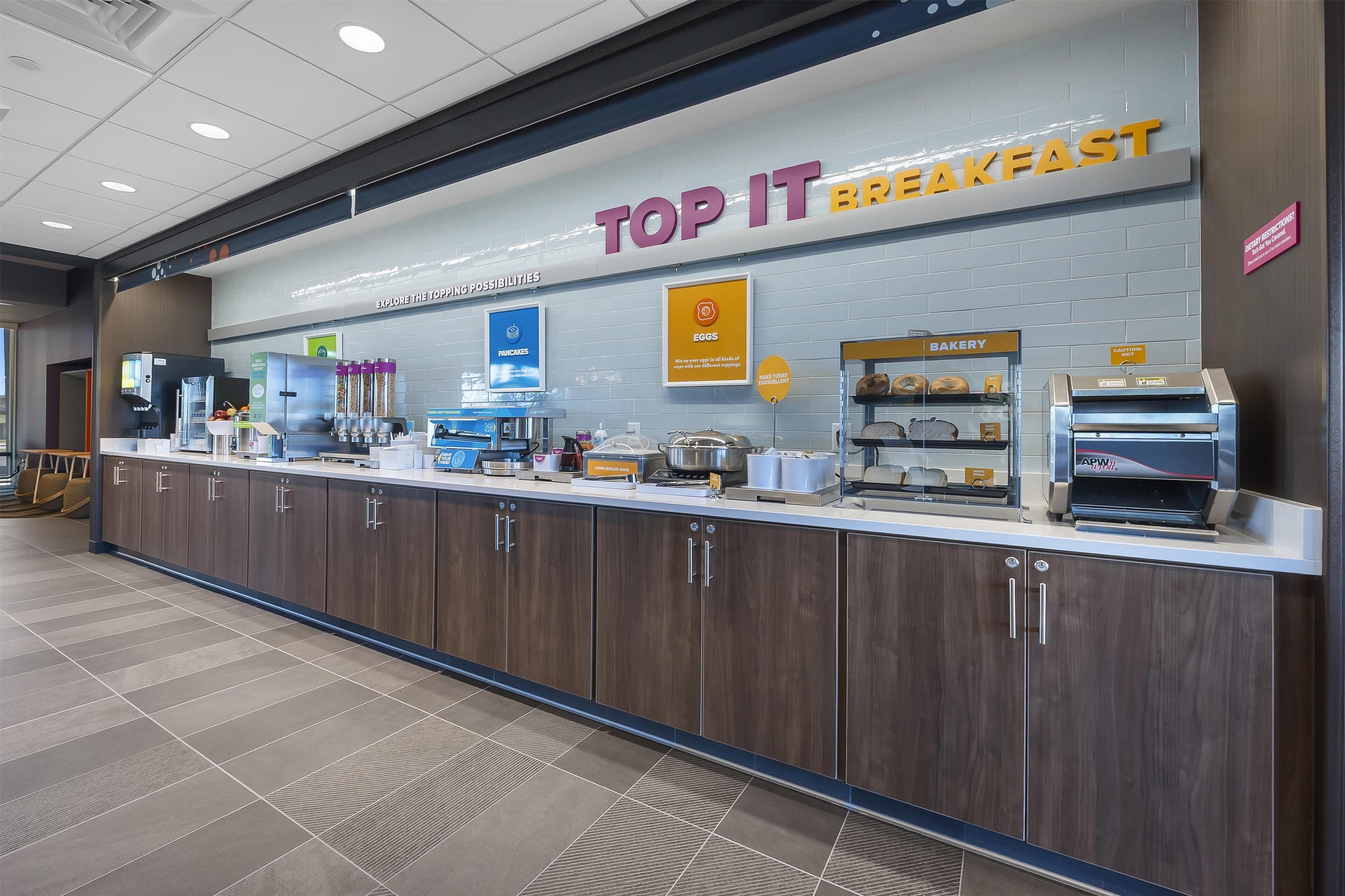 A breakfast area with a counter, cabinets, and a bakery display.