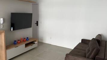 Apartamento luxo, acesso à piscina | Área de estar | Smart TV 55 polegadas com canais digitais, Netflix