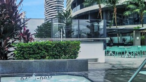 A rooftop pool with a view of modern buildings and palm trees. - Perfect beach pad Oracle Tower 2 Lvl 8 Parking (Broadbeach)