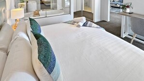 A hotel room with a large bed, a desk, a TV, and a view of the city. - Perfect beach pad Oracle Tower 2 Lvl 8 Parking (Broadbeach)
